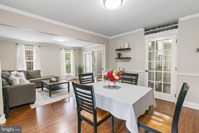 dining space with dark wood finished floors, ornamental molding, baseboards, and french doors