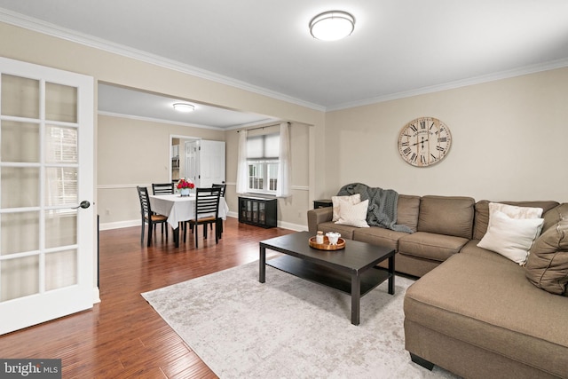 living area featuring wood finished floors, ornamental molding, and baseboards