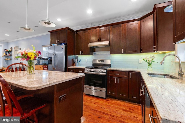 1248 N Hollywood St, Philadelphia, PA 19121 - kitchen with appliances with stainless steel finishes, under cabinet range hood, a sink, crown molding, and light stone counters