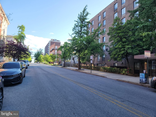 view of asphalt street featuring sidewalks and curbs