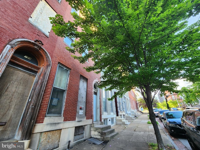 view of home's exterior with entry steps and brick siding