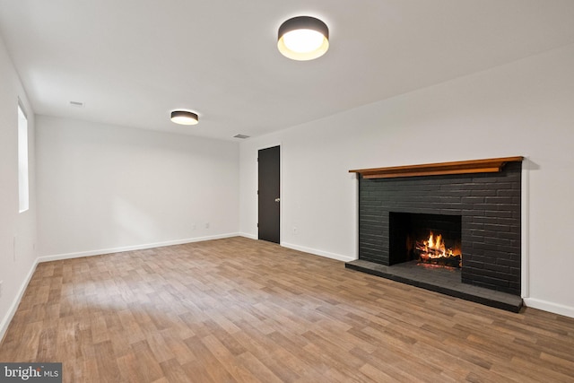4009 30th St N, Arlington, VA 22207 - unfurnished living room with a brick fireplace, wood finished floors, and baseboards