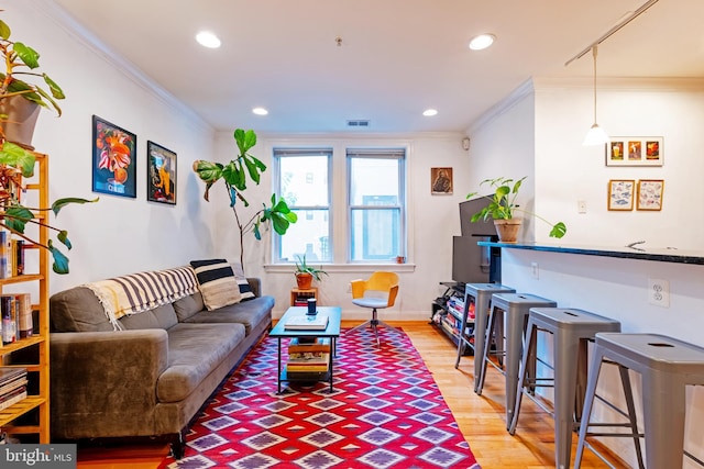 living area with crown molding, wood finished floors, recessed lighting, and baseboards