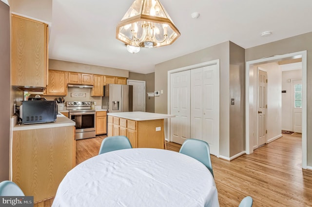 2452 Tuckahoe Ct, Waldorf, MD 20601 - kitchen with appliances with stainless steel finishes, under cabinet range hood, light countertops, light wood finished floors, and a chandelier