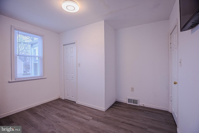 empty room featuring dark wood-style flooring and baseboards