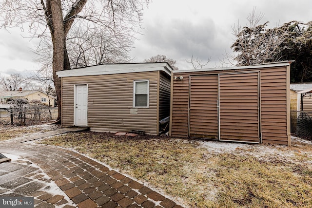 back of property featuring an outbuilding and fence