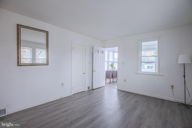 spare room featuring wood finished floors and baseboards