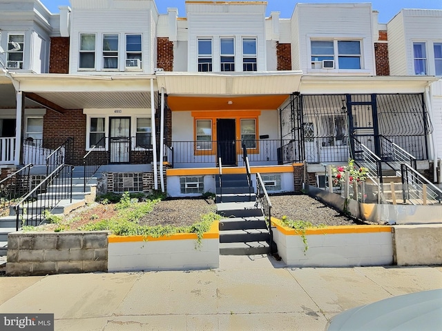 view of front of property with stairway, a porch, and brick siding