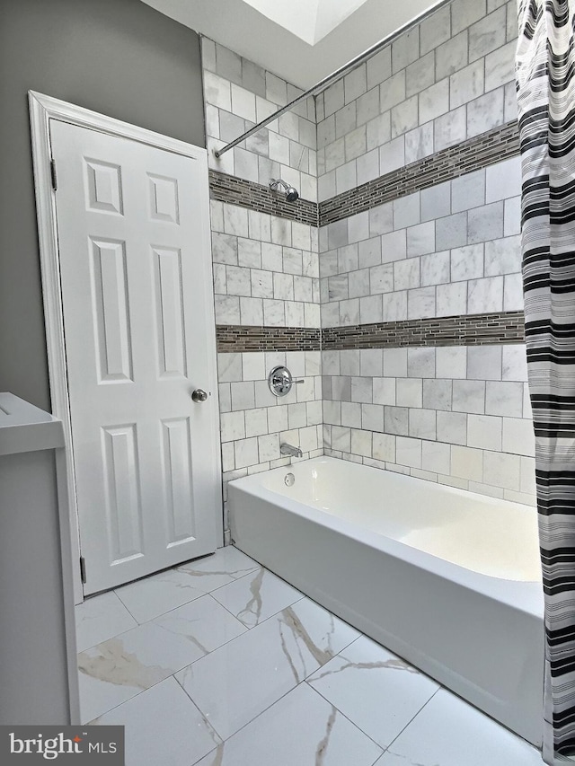 bathroom featuring shower / bath combination with curtain and marble look tiles