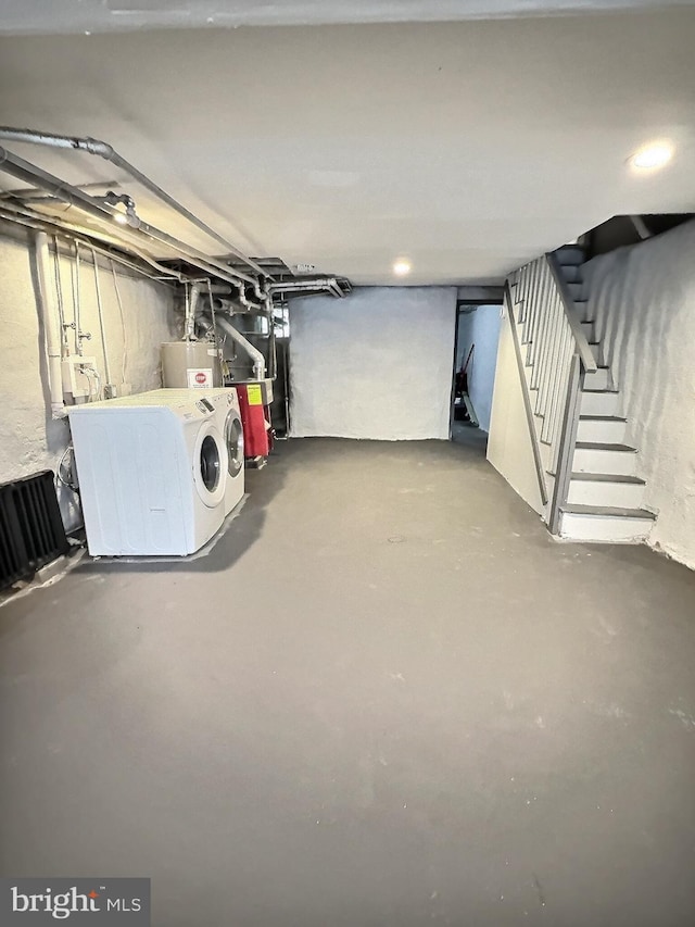 basement featuring washer and dryer, water heater, and stairway