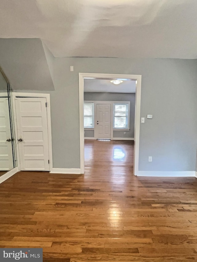 foyer entrance with wood finished floors and baseboards