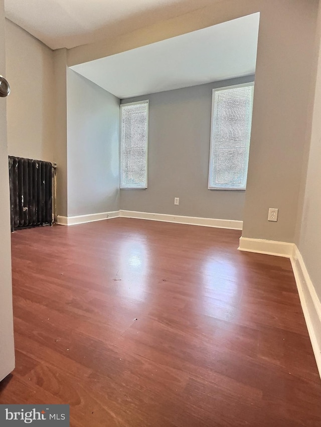 unfurnished living room featuring wood finished floors and baseboards