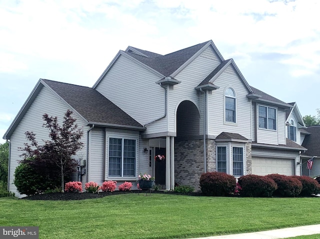 view of front of home featuring a front lawn, a garage, and a shingled roof