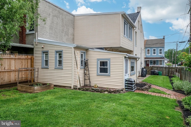 848 Houston St, Columbia, PA 17512 - back of property featuring roof with shingles, a vegetable garden, and a chimney