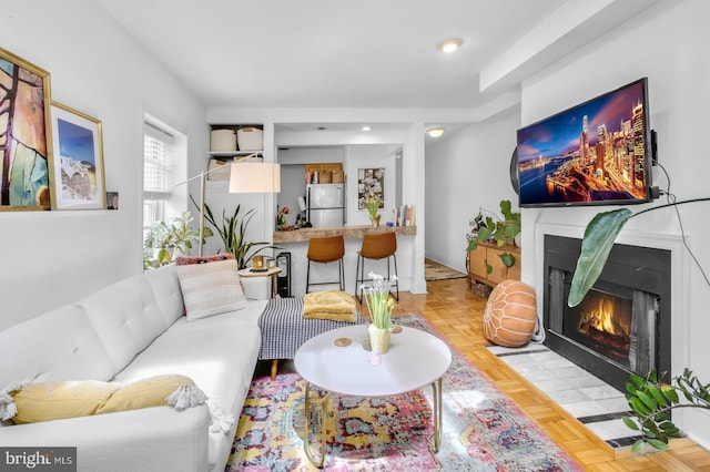 living room with a fireplace with flush hearth and recessed lighting