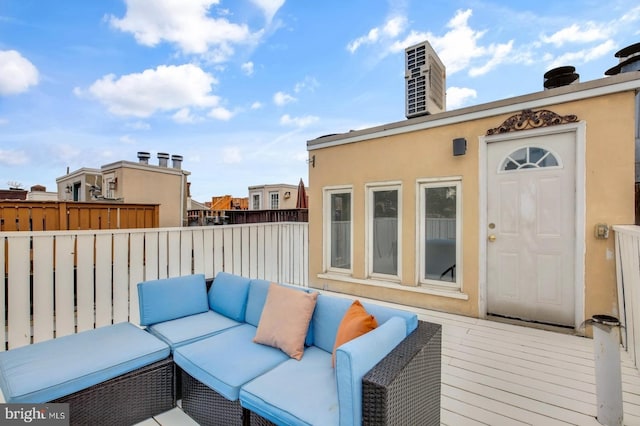 wooden terrace with an outdoor living space and fence