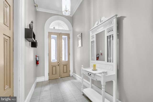 foyer featuring healthy amount of natural light, crown molding, and baseboards