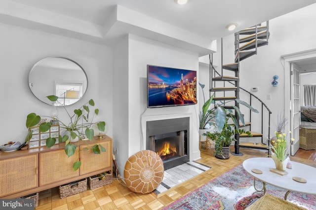 living area featuring stairs and a fireplace with flush hearth