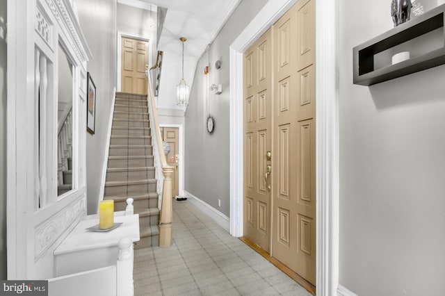 foyer entrance featuring stairway and baseboards