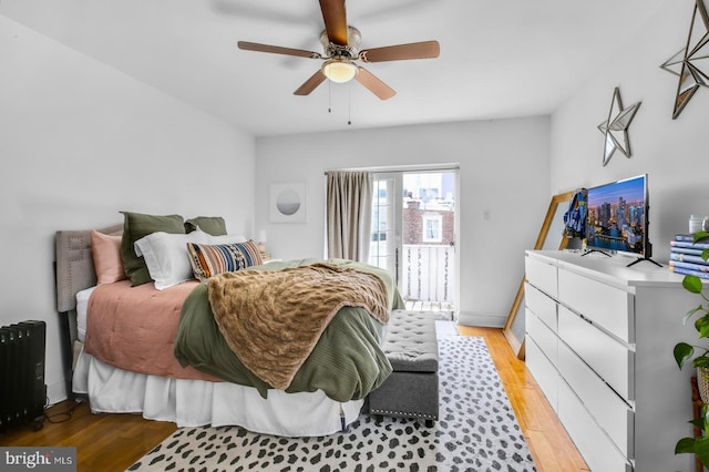 bedroom with radiator heating unit, light wood-style flooring, access to exterior, and ceiling fan