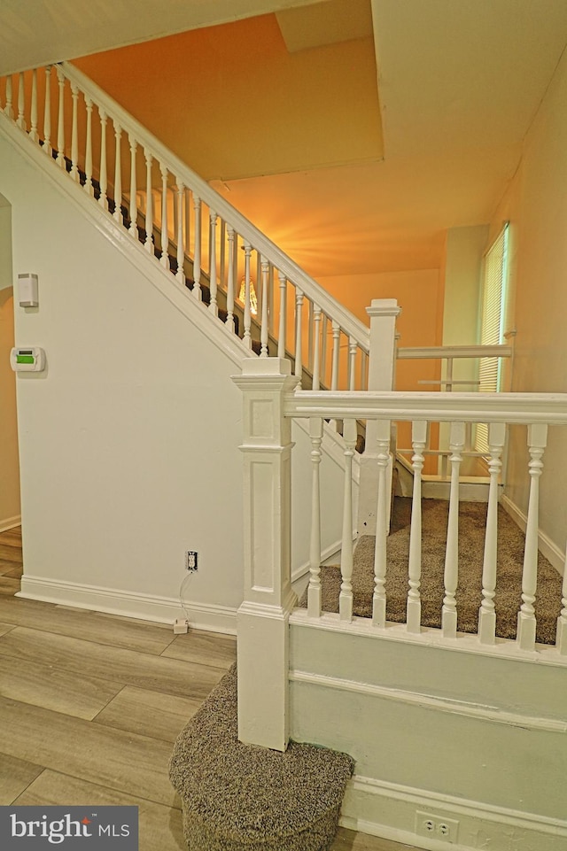 stairway featuring baseboards and wood finished floors
