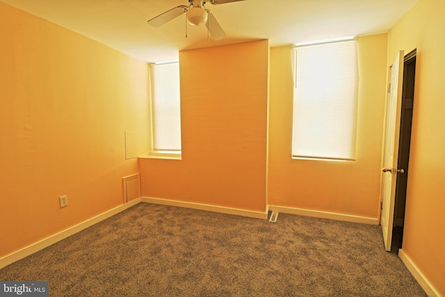 spare room with carpet, a ceiling fan, and baseboards