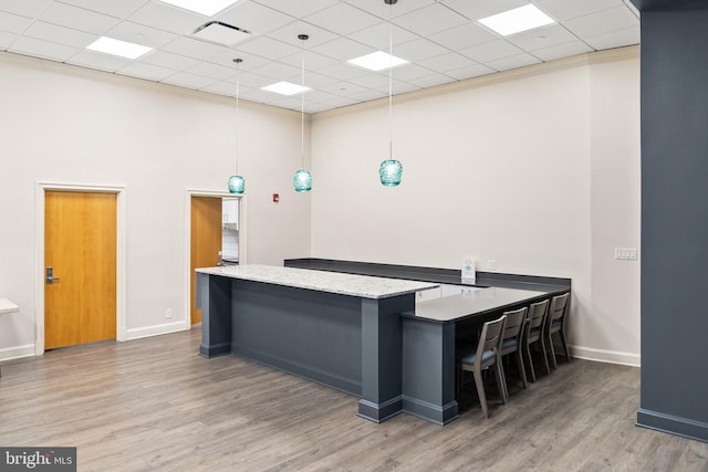 1300 Crystal Dr Unit 1408S, Arlington, VA 22202 - kitchen featuring wood finished floors, a towering ceiling, baseboards, a kitchen island, and a drop ceiling