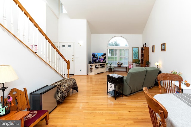 31142 Mills Chase Dr Unit 9, Lewes, DE 19958 - living room featuring high vaulted ceiling, stairs, light wood-style floors, and baseboards