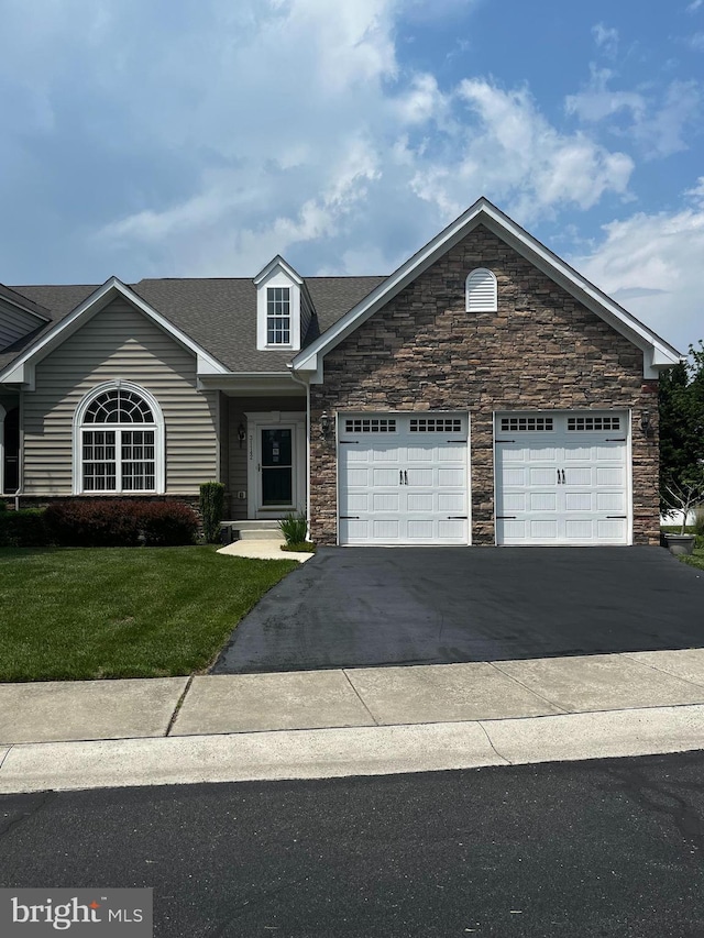 31142 Mills Chase Dr Unit 9, Lewes, DE 19958 - view of front of home featuring a garage, asphalt driveway, stone siding, a front lawn, and a shingled roof