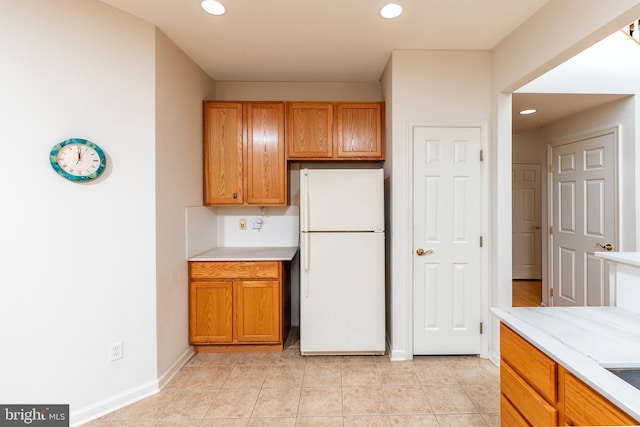 31142 Mills Chase Dr Unit 9, Lewes, DE 19958 - kitchen with freestanding refrigerator, recessed lighting, baseboards, light tile patterned floors, and brown cabinetry