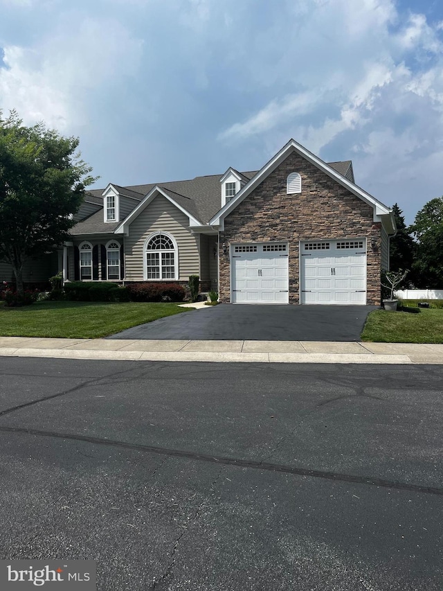 31142 Mills Chase Dr Unit 9, Lewes, DE 19958 - traditional home with stone siding, an attached garage, driveway, and a front lawn