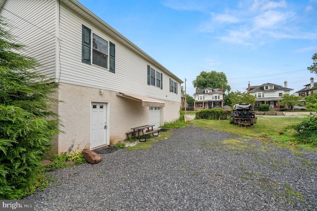 225 S Hanover St, Pottstown, PA 19465 - view of side of home with stucco siding, a garage, and driveway