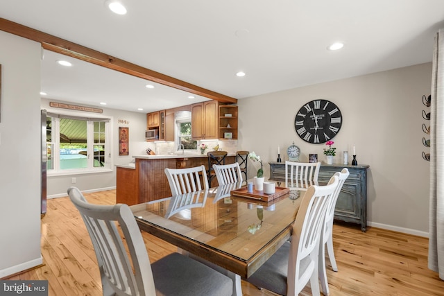 dining room with recessed lighting, baseboards, light wood finished floors, and beam ceiling