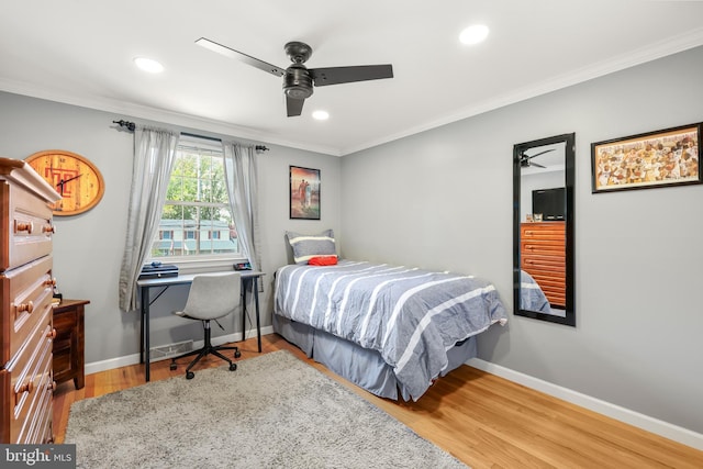 bedroom featuring baseboards, crown molding, wood finished floors, recessed lighting, and a ceiling fan