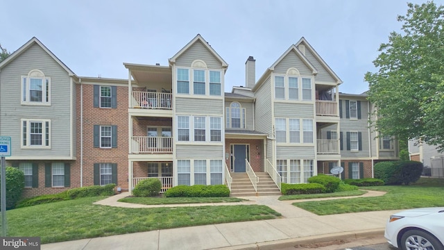 multi unit property featuring brick siding and a front lawn