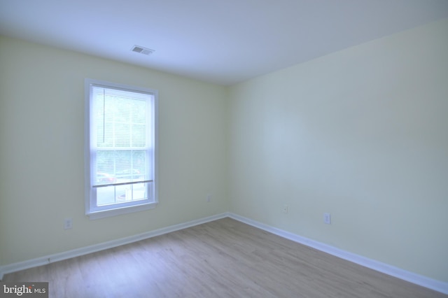 spare room with wood finished floors and baseboards