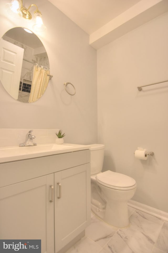 bathroom featuring marble look tiles, toilet, vanity, a shower with shower curtain, and baseboards