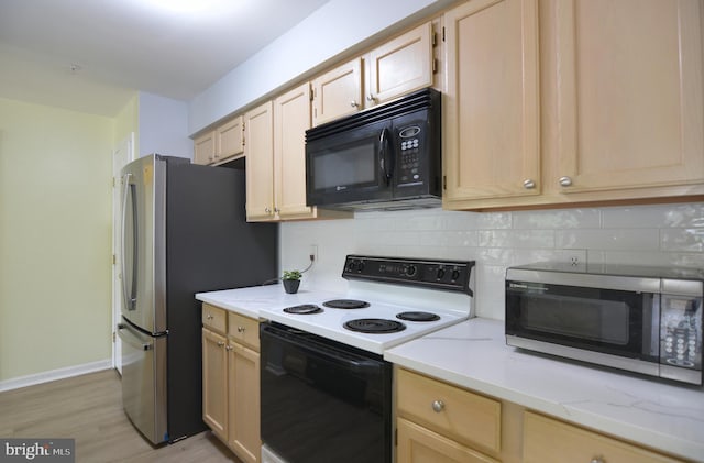 kitchen with appliances with stainless steel finishes, backsplash, light wood finished floors, light brown cabinets, and baseboards