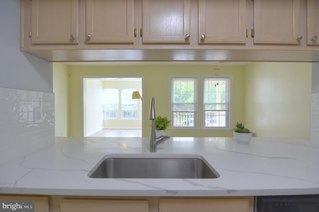 kitchen featuring a sink and light stone counters