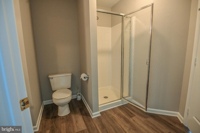 full bath featuring wood finished floors, a stall shower, and baseboards