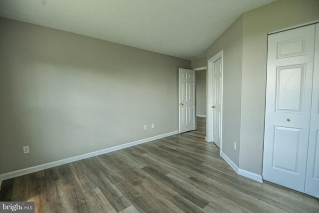 unfurnished bedroom with wood finished floors and baseboards