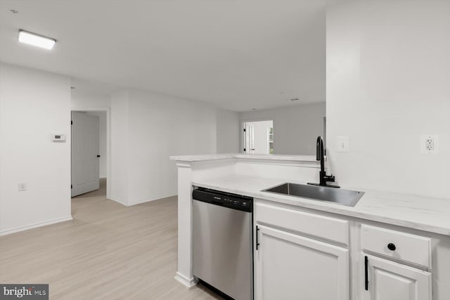 kitchen featuring stainless steel dishwasher, a sink, light wood-type flooring, and white cabinetry