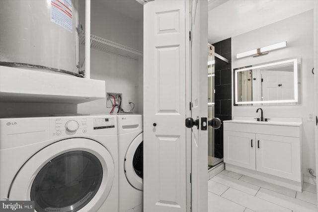 laundry room with a sink, light tile patterned flooring, and washer and dryer