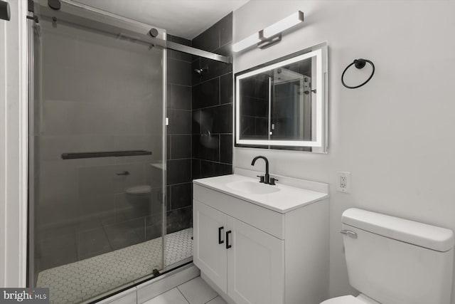 bathroom featuring toilet, a shower stall, vanity, and tile patterned floors
