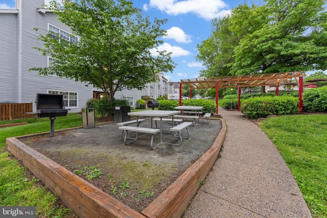 view of property's community featuring a pergola, outdoor dining area, and a lawn