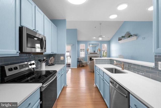 12708 Found Stone Rd Unit 3-304, Germantown, MD 20876 - kitchen with appliances with stainless steel finishes, light wood-type flooring, blue cabinetry, open floor plan, and light countertops