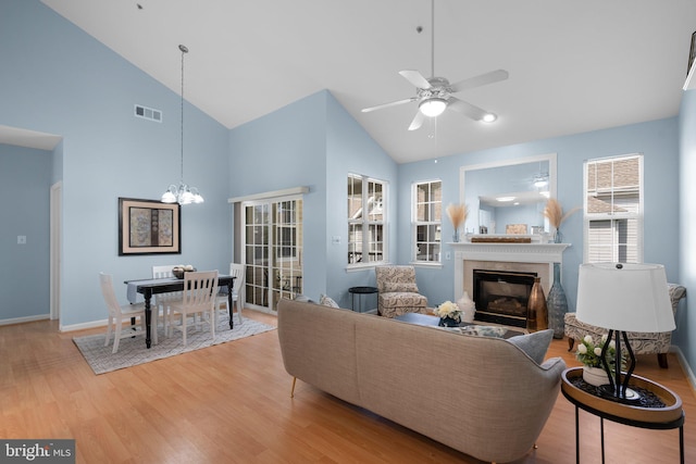 12708 Found Stone Rd Unit 3-304, Germantown, MD 20876 - living room with a glass covered fireplace, high vaulted ceiling, a ceiling fan, light wood-style flooring, and a chandelier