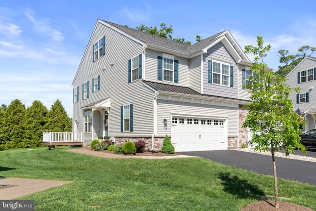 townhome / multi-family property featuring stone siding, driveway, an attached garage, a front yard, and metal roof