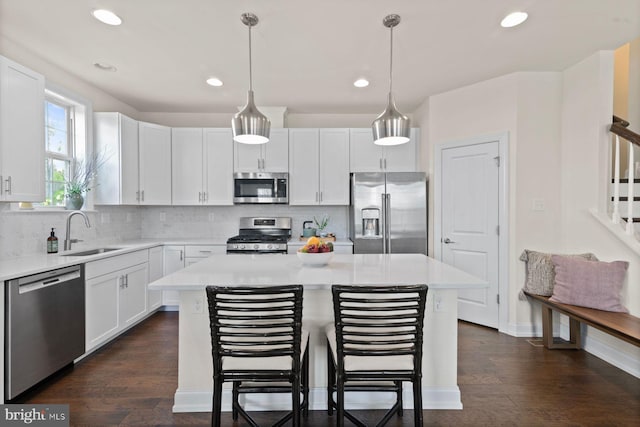 kitchen featuring stainless steel appliances, a sink, recessed lighting, light countertops, and decorative backsplash