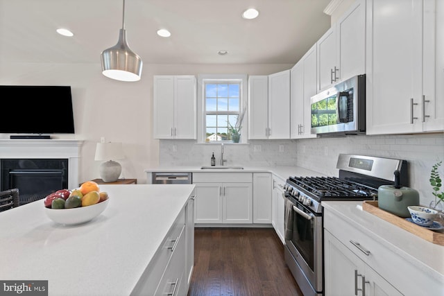 kitchen with stainless steel appliances, a sink, light countertops, recessed lighting, and decorative backsplash